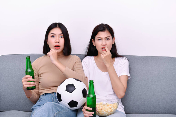 Concept of cheering. Asian teenagers watching football on television. People are cheering and winning football scores. - Foto, imagen