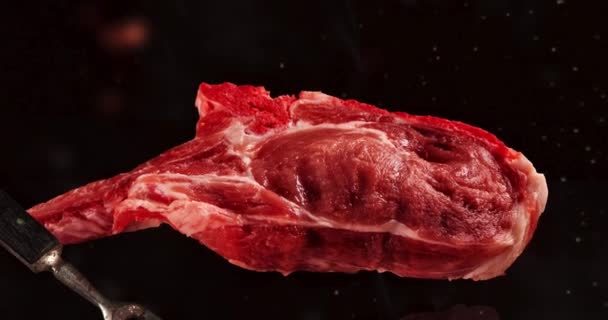 Flying pieces of pork chops steaks on black with motion slider effect - Záběry, video