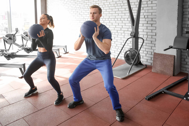 Young sporty couple working out together at gym - Zdjęcie, obraz