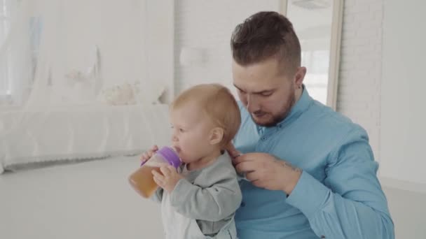 Farther dresses his beautiful daughter on knee. Happy family. Slow motion - Séquence, vidéo