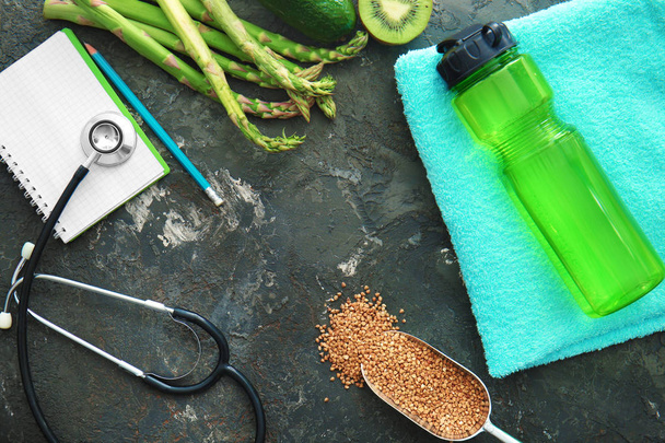 Stetoskop, defter ve koyu gri arka plan üzerinde sağlıklı gıda kompozisyonu - Fotoğraf, Görsel