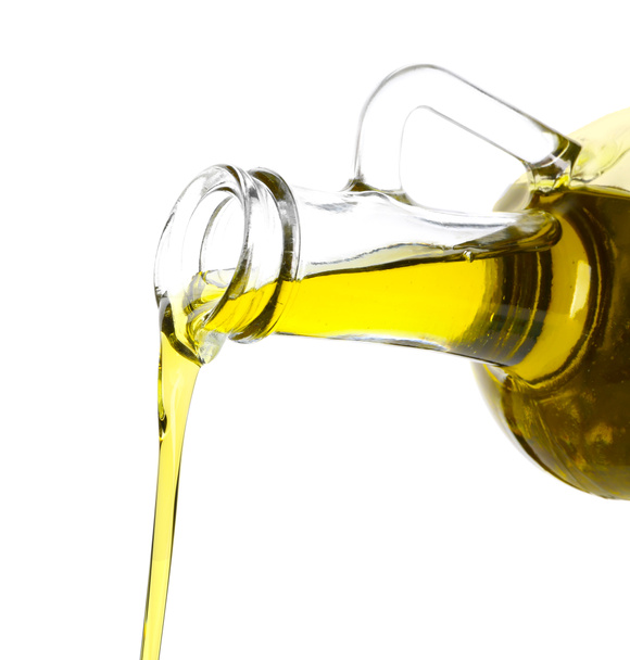 Versement d'huile d'olive à partir d'une cruche en verre sur fond blanc
 - Photo, image