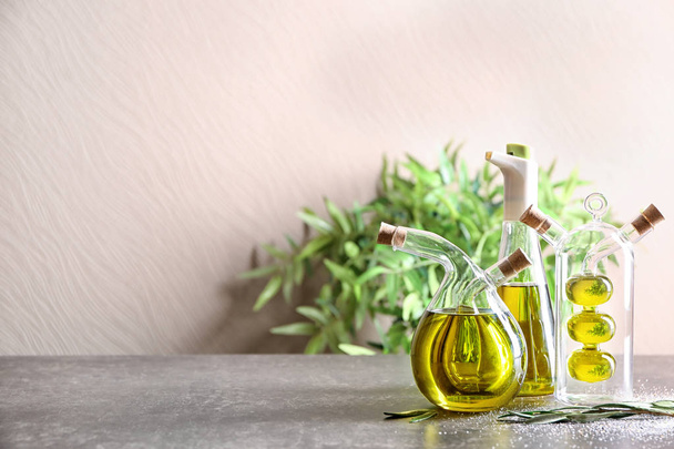 Beautiful composition with olive oil on table against light background - Photo, Image