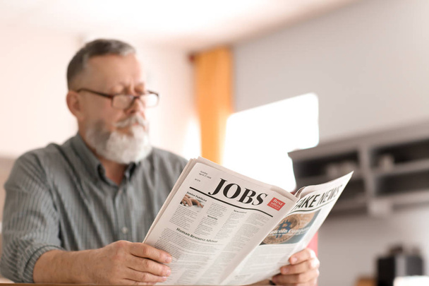 Ανώτερος άνθρωπος διαβάζει εφημερίδα στο σπίτι - Φωτογραφία, εικόνα