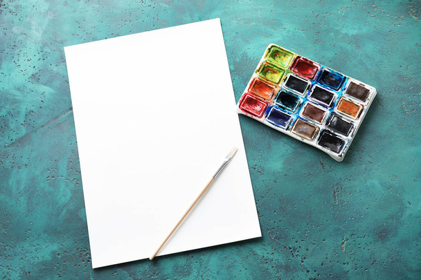 Aquarelle mit leerem Blatt Papier auf farbigem Hintergrund - Foto, Bild