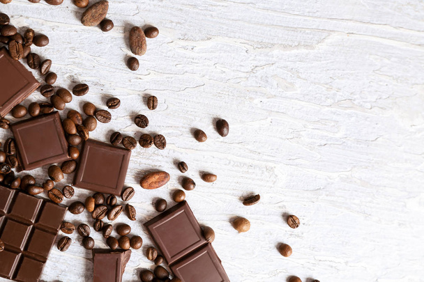 Вкусный шоколад с кофе и какао-бобы на светлом фоне
 - Фото, изображение