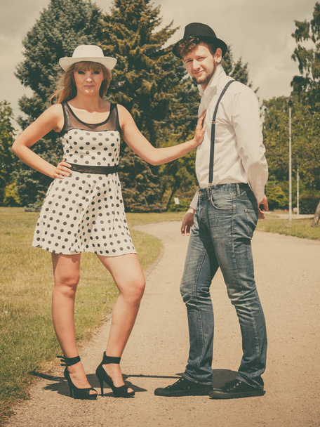 Summer holidays love relationship and dating concept - romantic playful couple retro style flirting in park - Fotó, kép