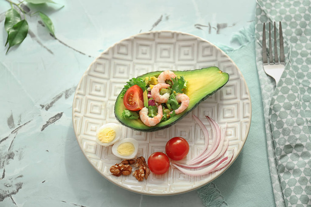 Piatto con gustoso avocado e insalata di gamberetti sul tavolo
 - Foto, immagini