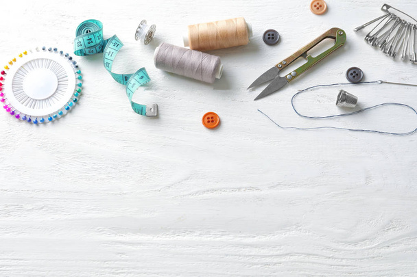Sewing accessories on white wooden background - Fotoğraf, Görsel