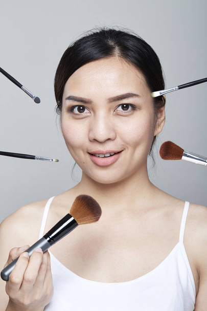 Beauty asian woman portrait cosmetics with make-up brushes near face,  Fashion Model Girl. Perfect Skin. Looking at camera studio shot - Fotoğraf, Görsel