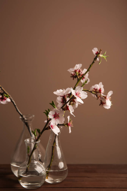 色背景にテーブルの上の美しい開花枝が付いているつぼ - 写真・画像