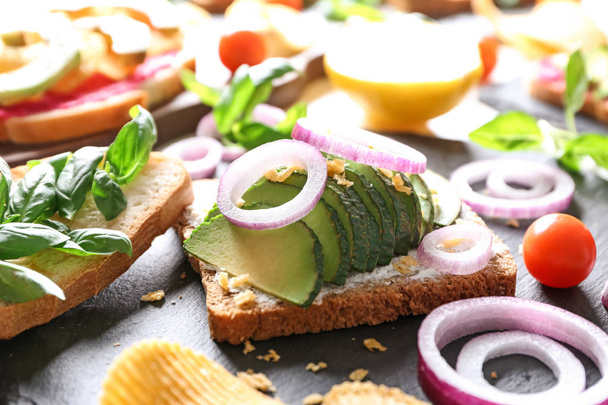 Delicious toast with avocado on slate plate - Photo, Image