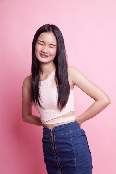 Young Asian woman got back pain on pink background - 写真・画像