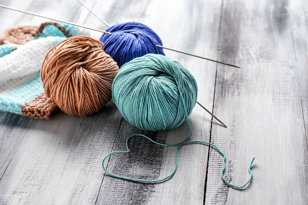 Knitting yarn with needles on wooden table - Фото, зображення