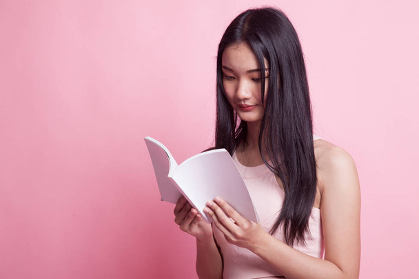 Young Asian woman read a book on pink background - Φωτογραφία, εικόνα