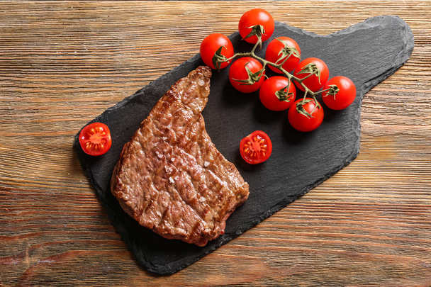 Delicious grilled steak with tomatoes on slate plate - Fotografie, Obrázek