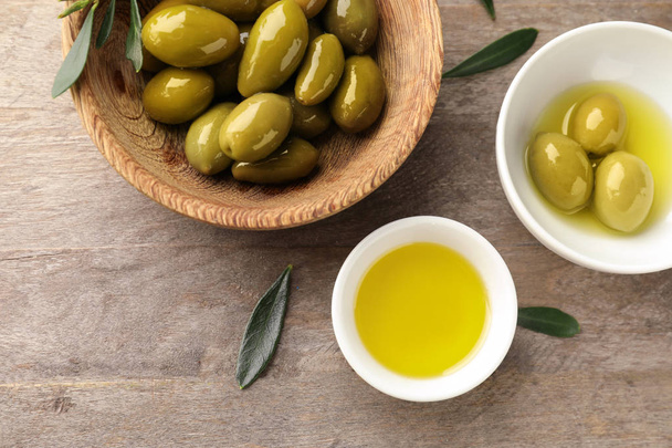 Bol à huile et olives sur table en bois
 - Photo, image