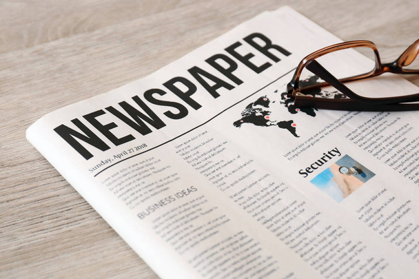 Newspaper with glasses on wooden background - Photo, Image