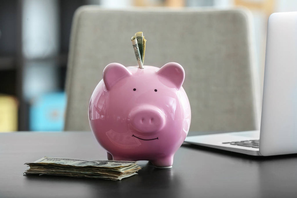 Свинка с деньгами на столе. Концепция экономии
 - Фото, изображение