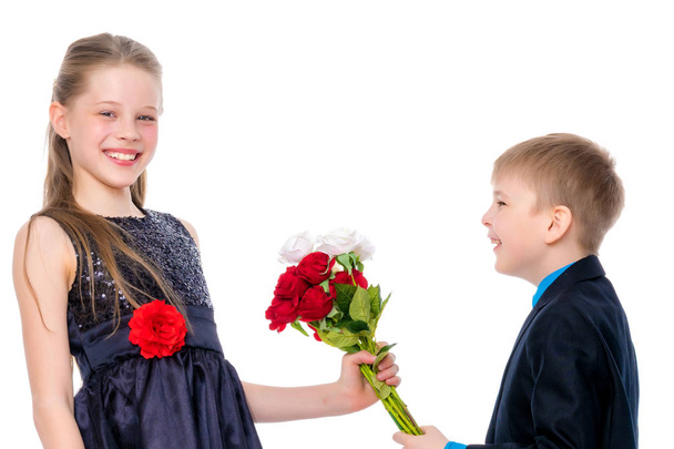 A little boy gives the girl flowers. - Foto, imagen