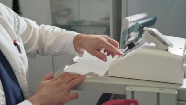 Close-up o cirurgião em um vestido de vestir estéril branco trabalha em um hospital com equipamento médico. Um médico em um laboratório clínico realiza um exame de sangue
. - Filmagem, Vídeo