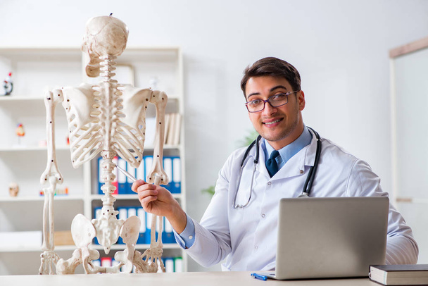 Yong médecin masculin avec squelette isolé sur blanc - Photo, image