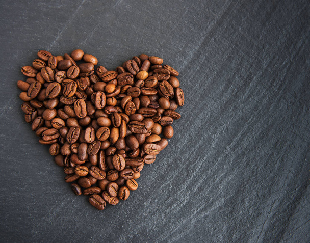 Coffee beans in the form of heart on black background - Fotó, kép