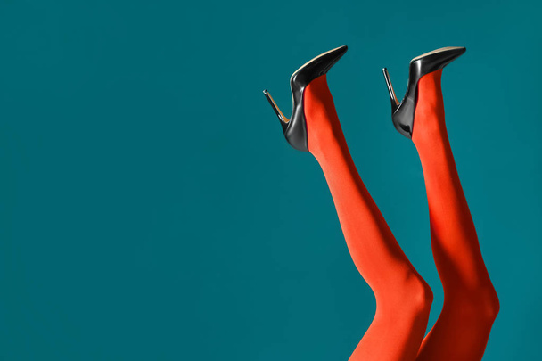 Legs of beautiful young woman in tights on color background - 写真・画像