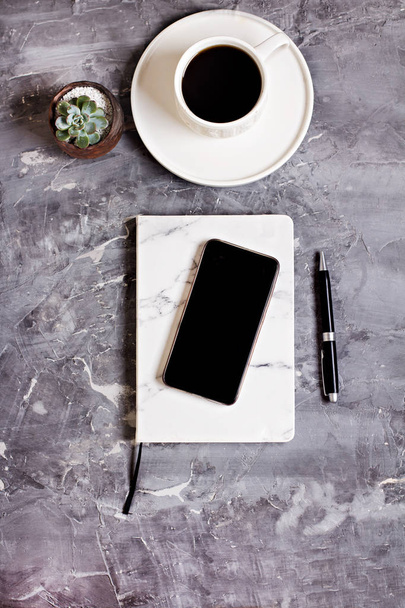 Блокнот, мобильный телефон, ручка, сочный, стаканы, чашка кофе на сером цементном фоне. Концепция бизнеса
. - Фото, изображение