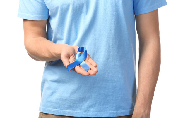 Hombre sosteniendo cinta azul sobre fondo blanco. Concepto de cáncer de próstata
 - Foto, Imagen