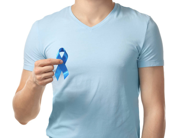 Man holding blue ribbon on white background. Prostate cancer concept - Zdjęcie, obraz