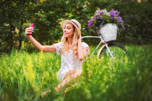beautiful young girl with vintage bicycle and flowers on city ba - Photo, Image
