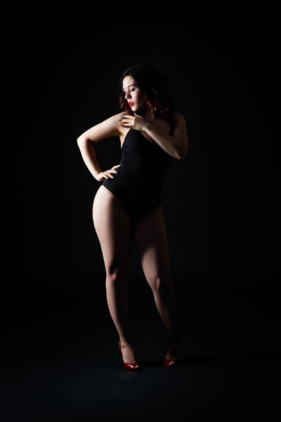 Beautiful sexy woman in bodysuit posing on black studio background, perfect female body, low key studio shot - Fotoğraf, Görsel
