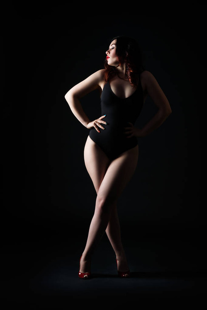 Beautiful sexy woman in bodysuit posing on black studio background, perfect female body, low key studio shot - Fotografie, Obrázek
