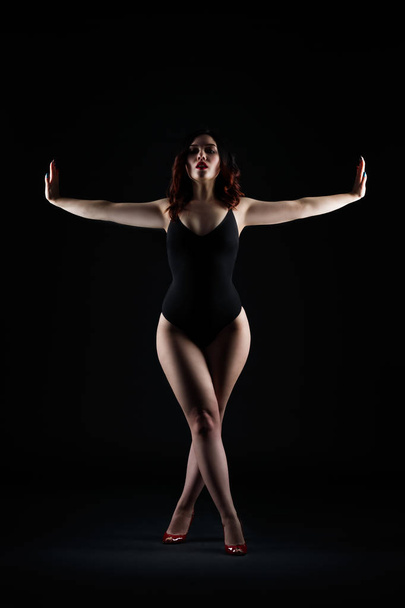 Beautiful sexy woman in bodysuit posing on black studio background, perfect female body, low key studio shot - Foto, immagini