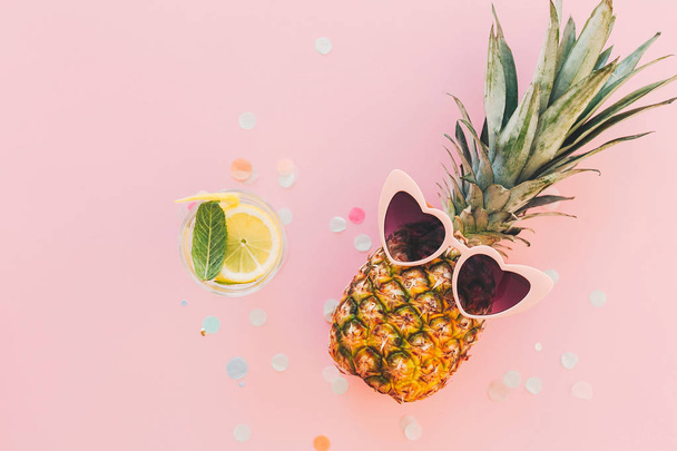 Stylový ananas v růžové brýle a mojito koktejl nápoj na módní růžové pozadí s konfety. plochý lay. prostor pro text. Letní dovolená a strana koncepce - Fotografie, Obrázek