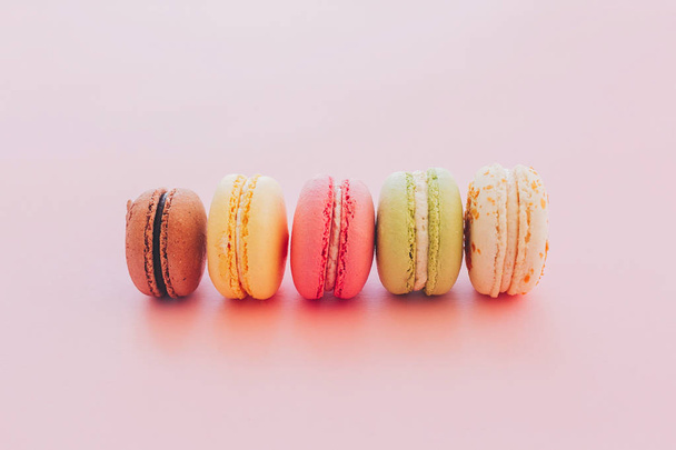 stylish colorful macaroons on trendy pink paper. space for text.tasty pink, yellow, green, white, brown macarons. yummy background. modern food photography concept - Fotografie, Obrázek