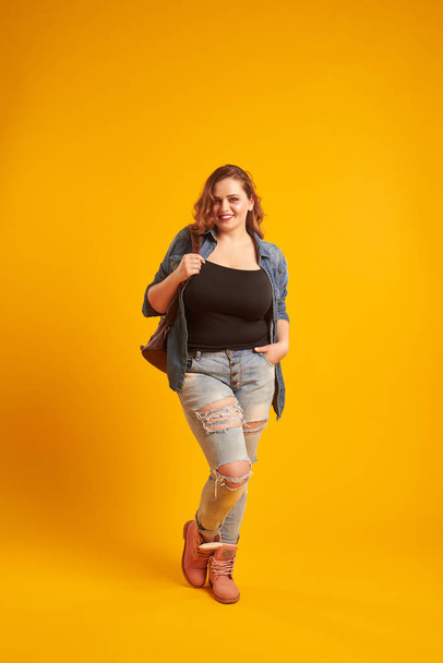 Urban plus-size model posing with backpack and looking at camera - Photo, Image