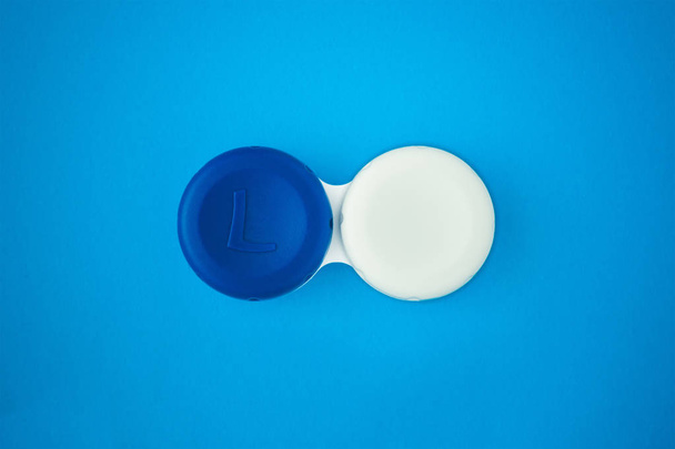футляр для контактных линз на синем фоне
 - Фото, изображение