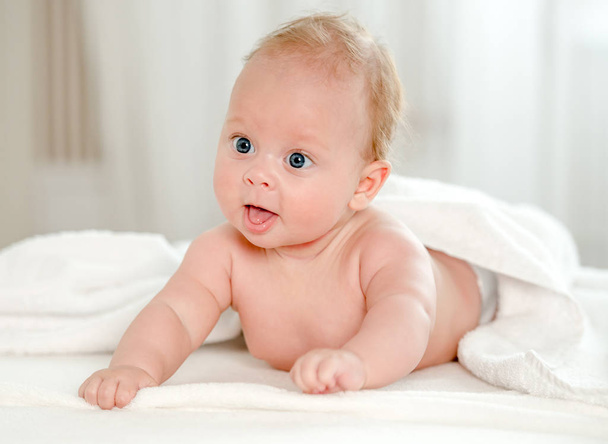 Newborn baby with beautiful blue eyes lying on belly - Foto, imagen