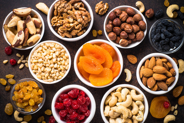 Nuts and dried fruits assortment on stone table top view. - Photo, Image