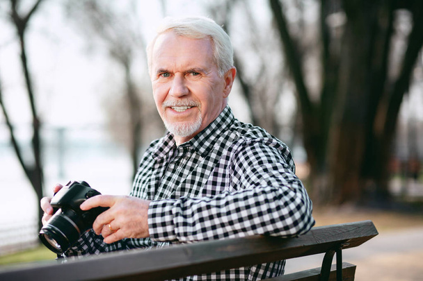 Pleasant mature man learning photography - Foto, Imagen