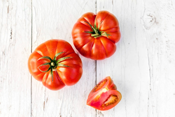  Red Fresh tomatoes on old wooden table in rustic style, top view  - Foto, afbeelding