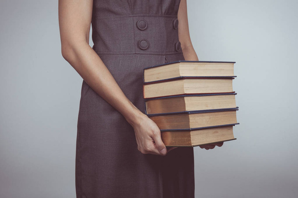 Vintage tone of woman carrying a pile of books at office - Foto, Bild