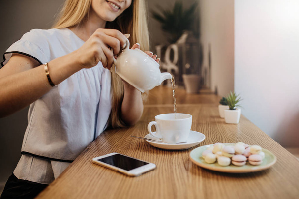 Woman with phone and hot  tea  - Фото, изображение