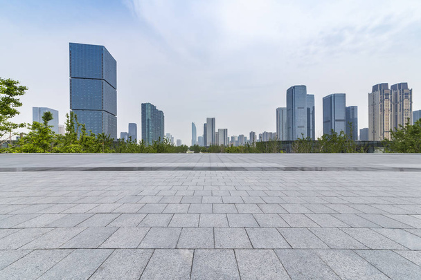 skyline panorámico y modernos edificios de oficinas de negocios con camino vacío, piso cuadrado de hormigón vacío - Foto, Imagen