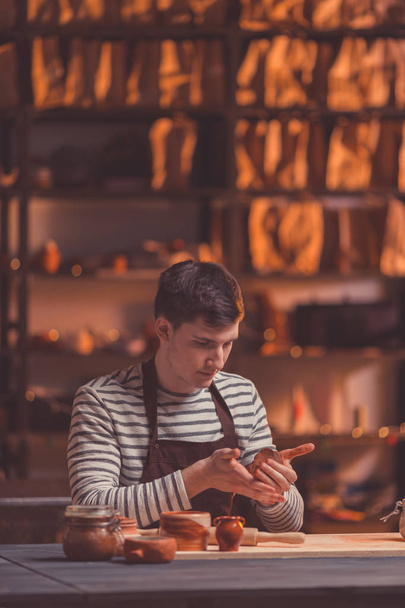 Young man in a pottery studio - Foto, afbeelding