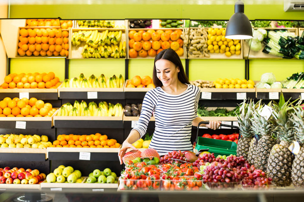 woman holding basket and buying fruits in supermarket - Foto, afbeelding