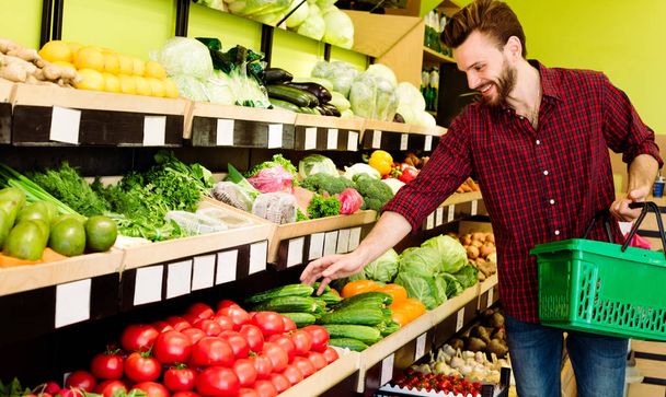 Caucasian man in red checkered shirt choosing vegetables in grocery - Zdjęcie, obraz