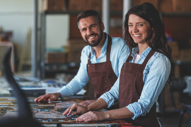 Lächelnde Menschen mit Mosaik im Atelier - Foto, Bild